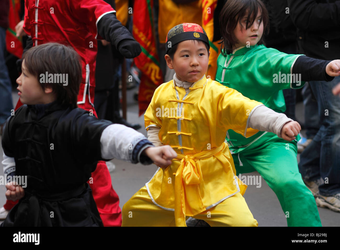 Les jeunes garçons effectuant les arts martiaux à la parade du Nouvel An chinois dans les rues de Paris, France Banque D'Images