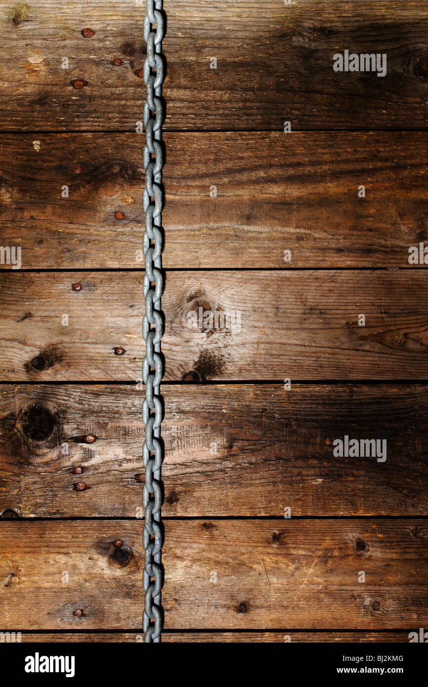 Une chaîne pendant vers le bas d'un mur en bois rustique. Banque D'Images