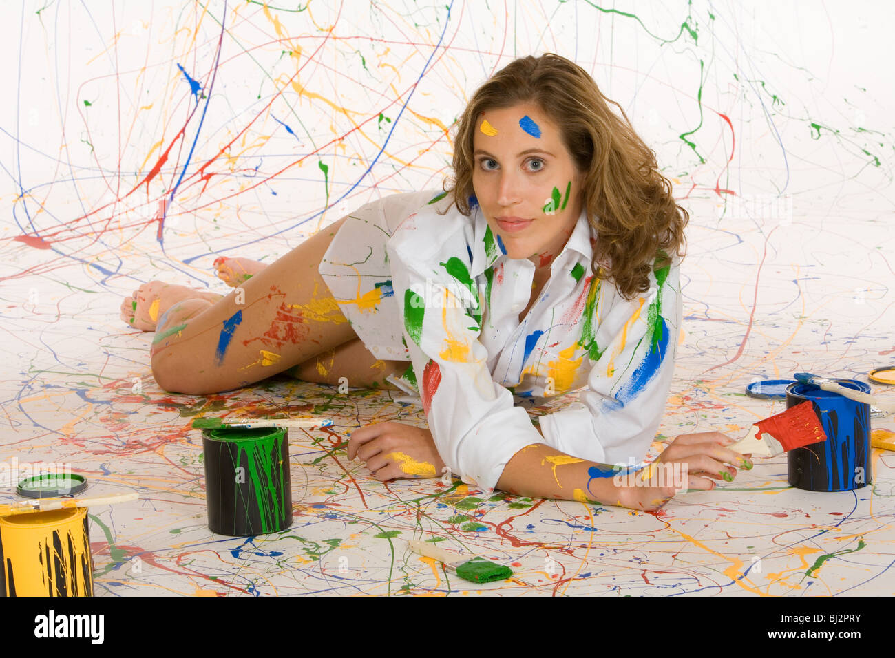 Femme à la mi 20s s'amusant de faire une peinture de mess Banque D'Images