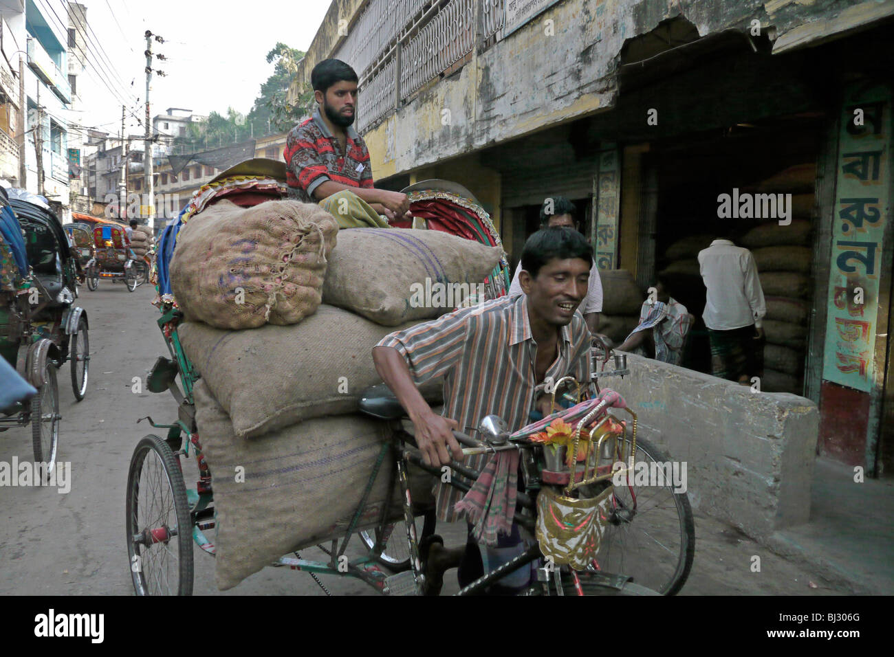 Le BANGLADESH Rickshaw transportant une charge lourde, vieille de Dhaka. PHOTO par SEAN SPRAGUE Banque D'Images