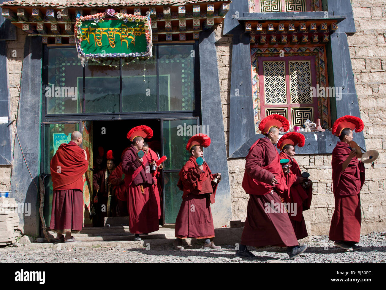 Les lamas ou les moines d'un monastère au Tibet effectuer une cérémonie religieuse avec la musique et le chant à l'extérieur de leur temple. Banque D'Images