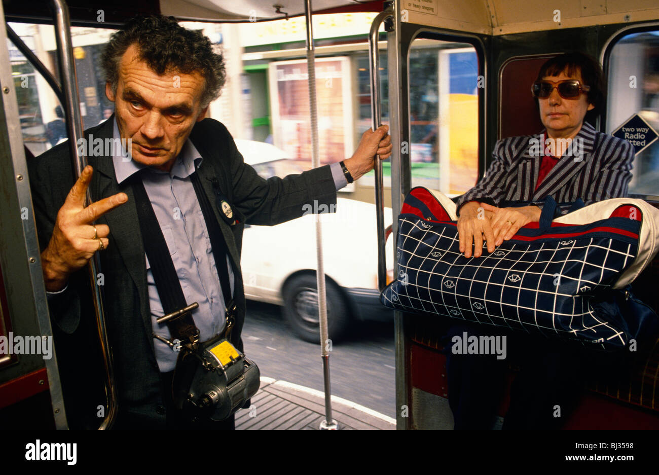 Vend un billet de train tout en voyageant le long d'une route de Londres, dans le cadre d'un équipage de deux hommes d'un certain nombre 88 red London Routemaster. Banque D'Images