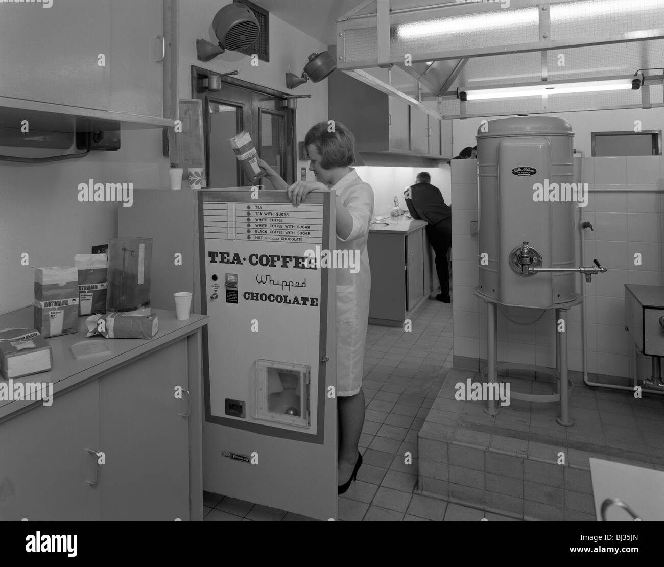 Chargement d'un distributeur de boissons à une cuisine expérimentale à Sheffield, South Yorkshire, 1966. Artiste : Michael Walters Banque D'Images