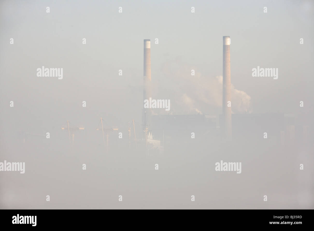 Clearing matin brouillard sur la Tamise révèle un navire de passage et de hautes cheminées de npower 1400MW chimneys Banque D'Images