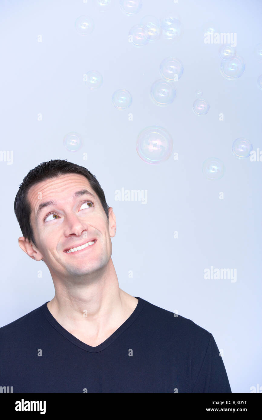 Smiling man looking at bubbles Banque D'Images