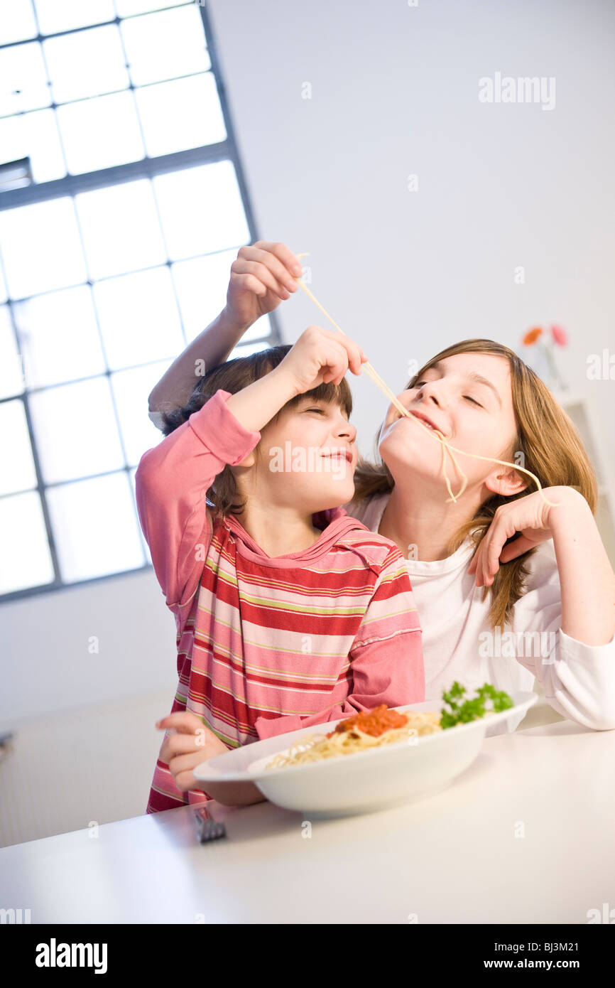 Deux filles de manger ensemble spaghetti Banque D'Images