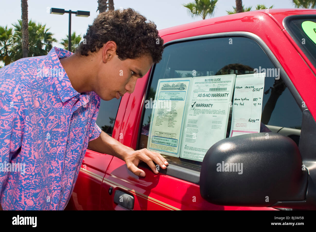 16-18 ans ans hispaniques/African American young man shopping pour son premier véhicule concessionnaire concessionnaire Ford vente voiture lot. Californie Banque D'Images