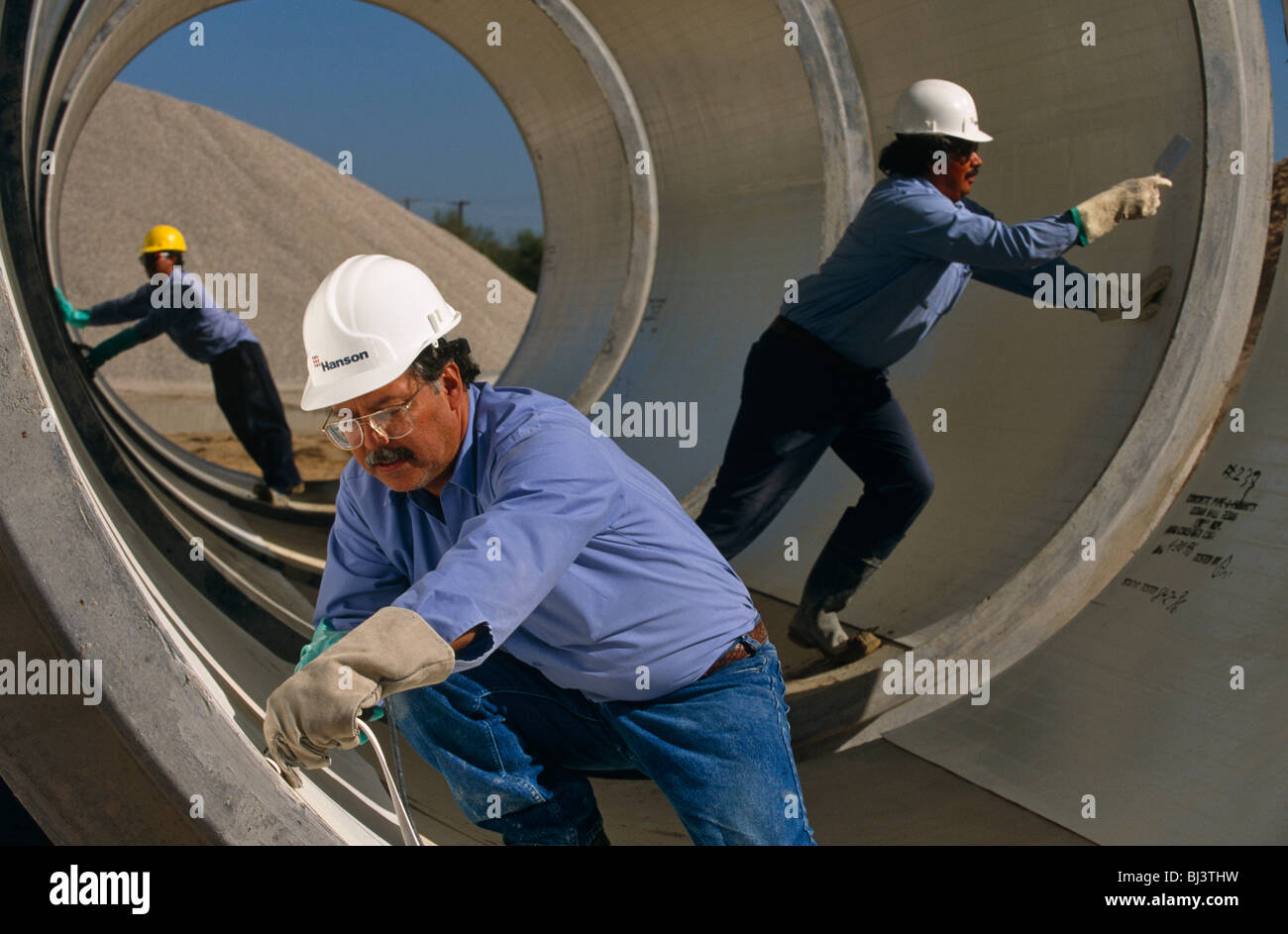 Les tuyaux de béton préfabriqué sont prêts pour la distribution par un Mexicain né-employés de Hanson Pipe & Products, Grand Prairie, Texas Banque D'Images