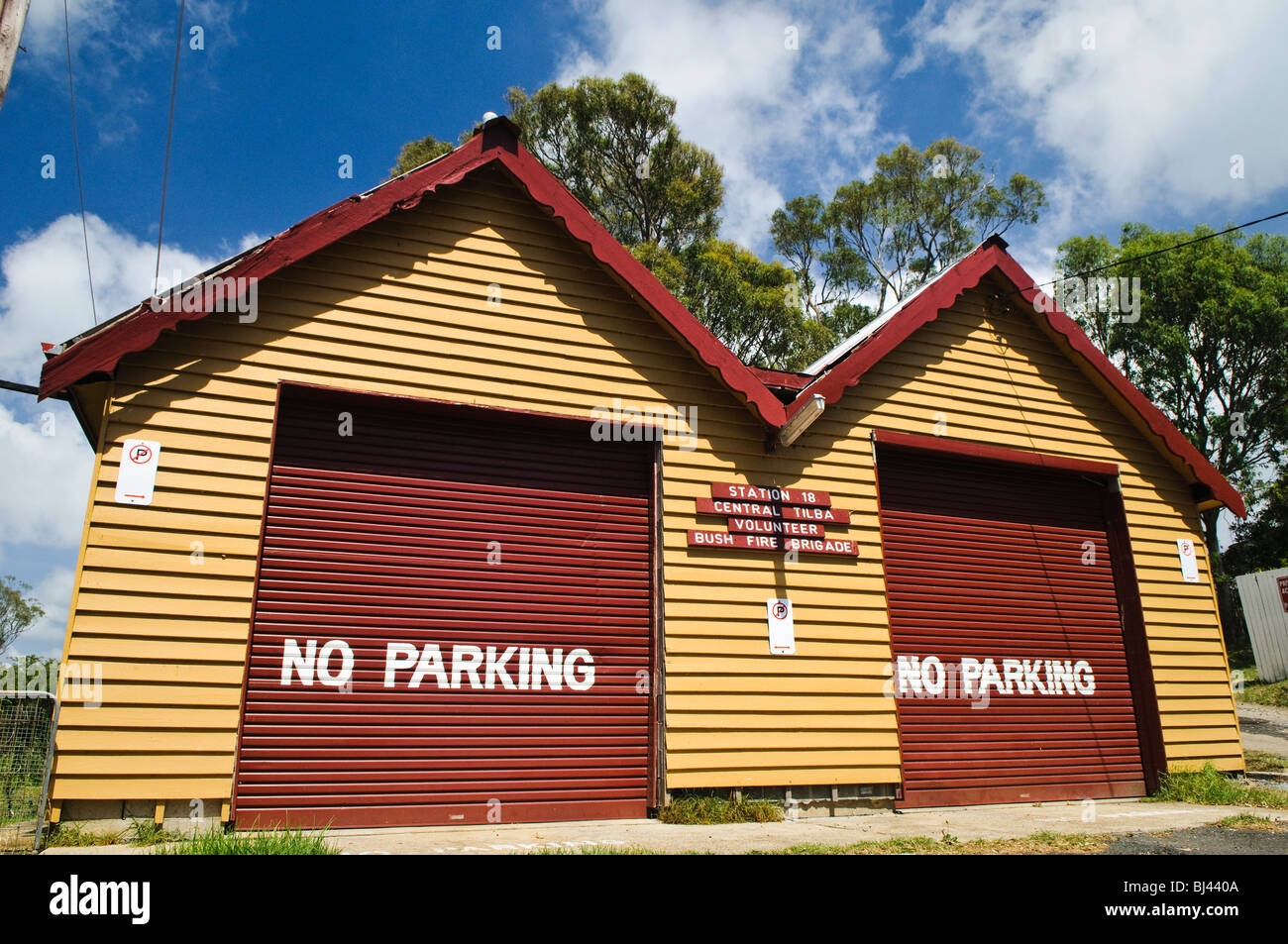 Central Tilba main Street architecture historique Central Tilba Australia // CENTRAL TILBA, Australia — la station 18 de la Central Tilba Volunteer Bush Fire Brigade est logée dans ce bâtiment jaune distinctif avec des portes de garage rouges. Le bâtiment présente une architecture rurale australienne classique et sert de ressource communautaire vitale dans le village historique de Central Tilba, en Nouvelle-Galles du Sud. Banque D'Images