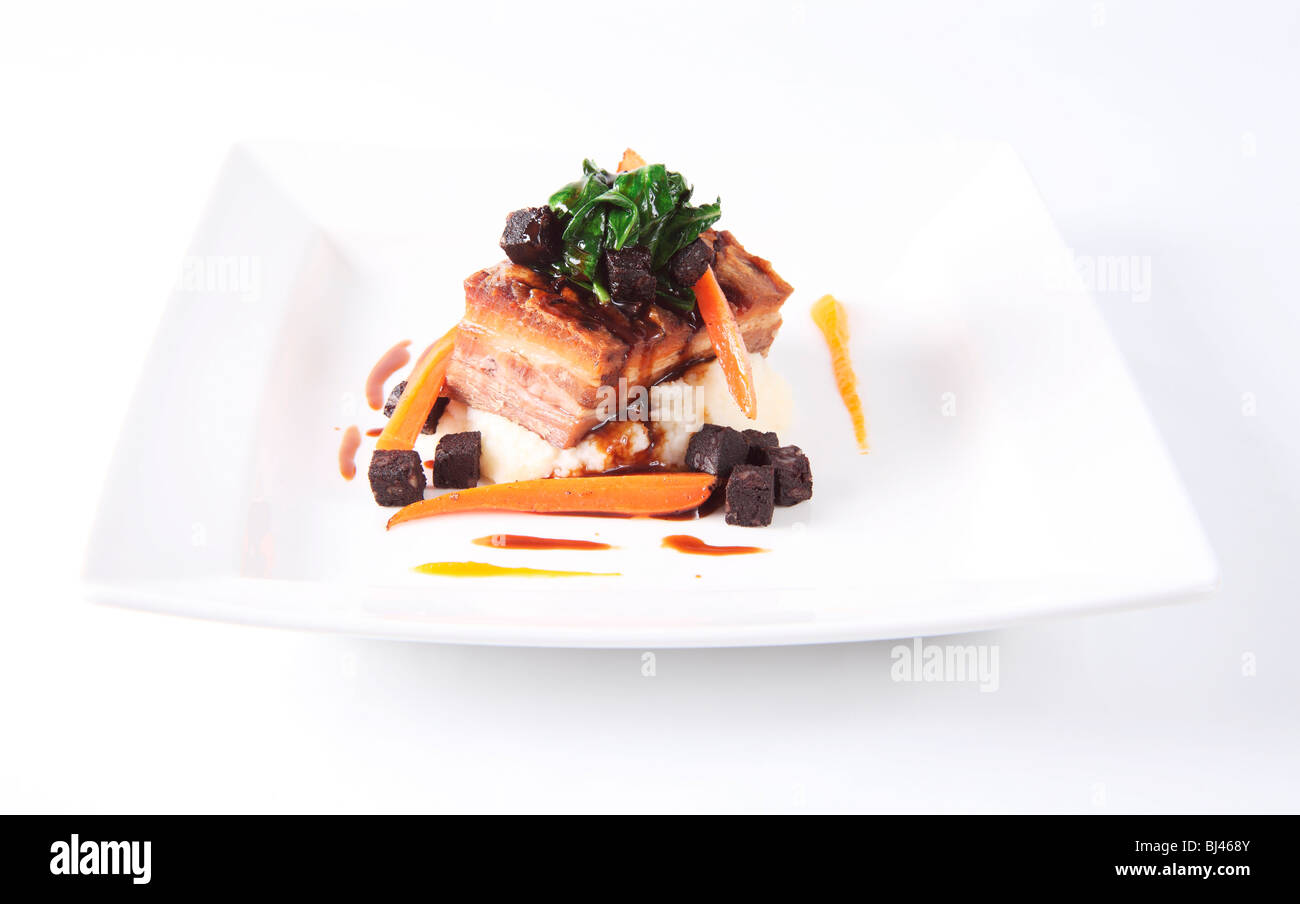 Ventre de porc rôti avec du boudin noir et du bacon Mash Banque D'Images