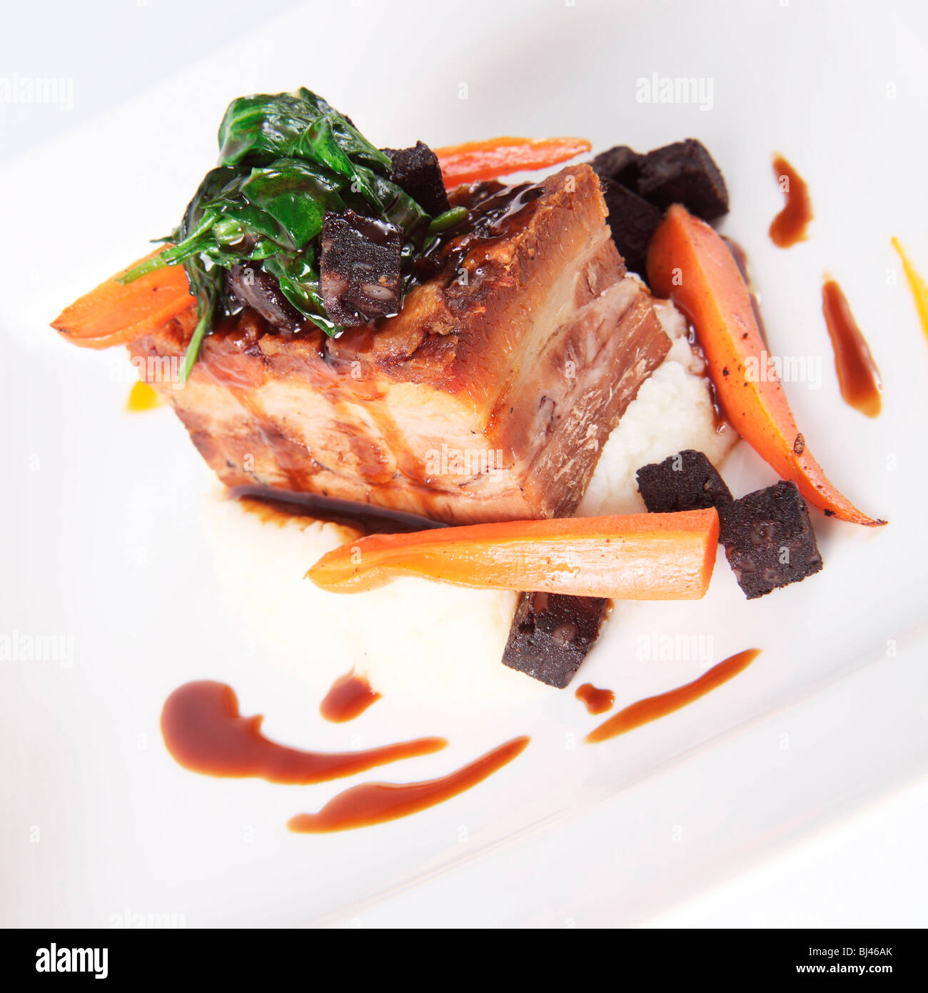 Ventre de porc rôti avec du boudin noir et du bacon Mash Banque D'Images