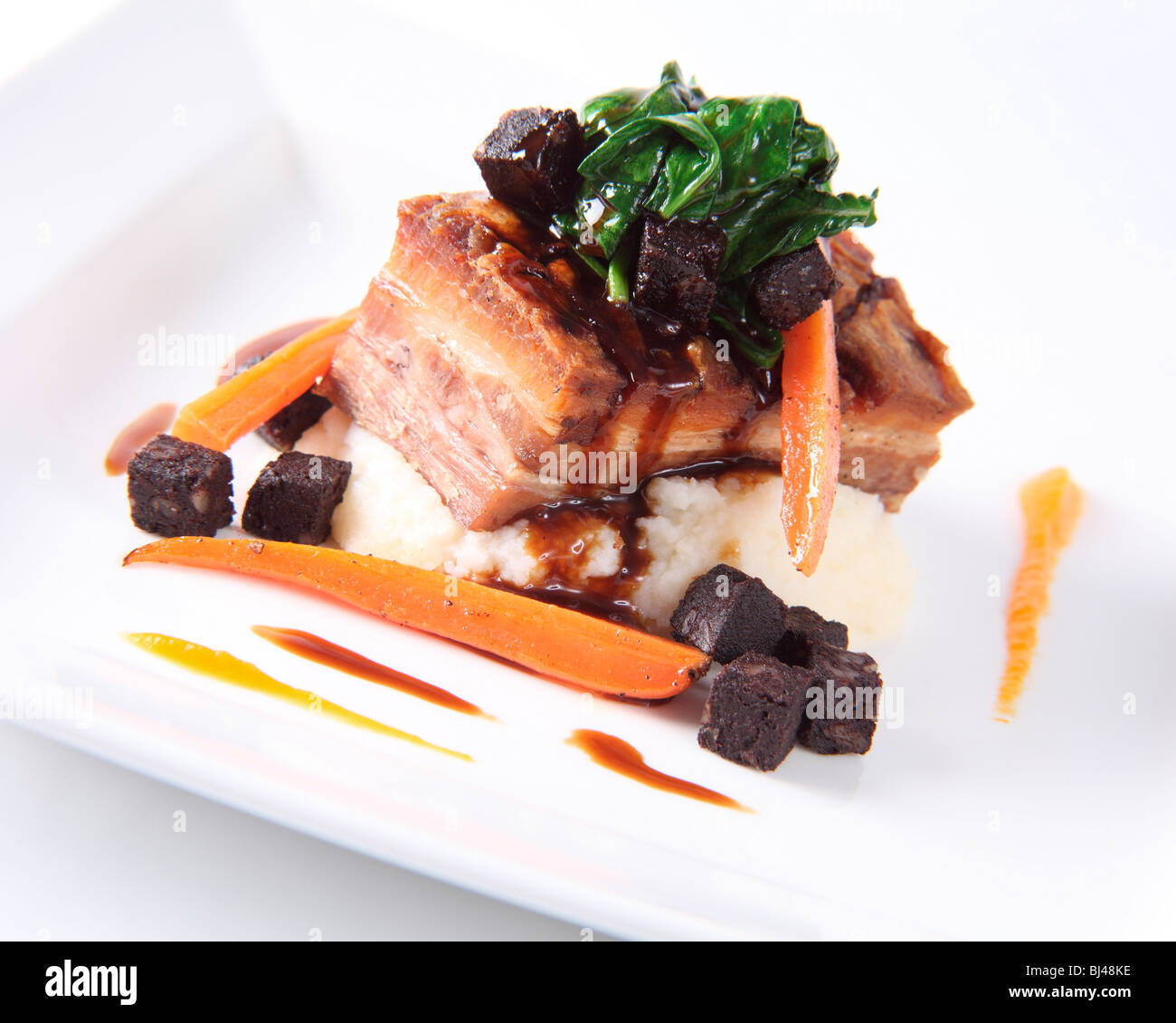 Ventre de porc rôti avec du boudin noir et du bacon Mash Banque D'Images