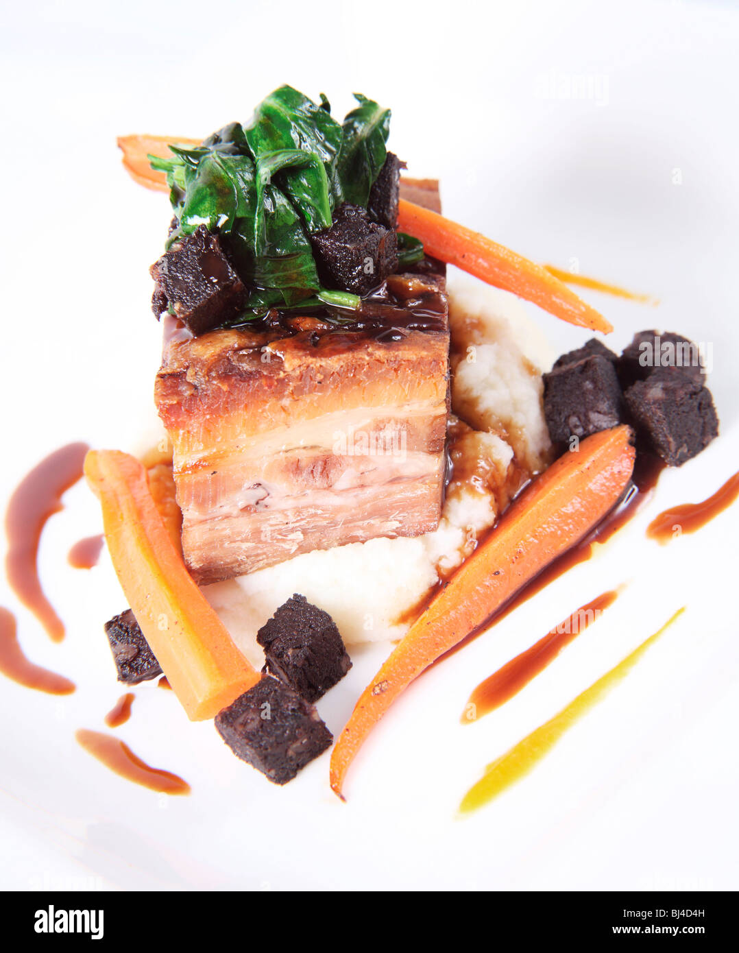 Ventre de porc rôti avec du boudin noir et du bacon Mash Banque D'Images