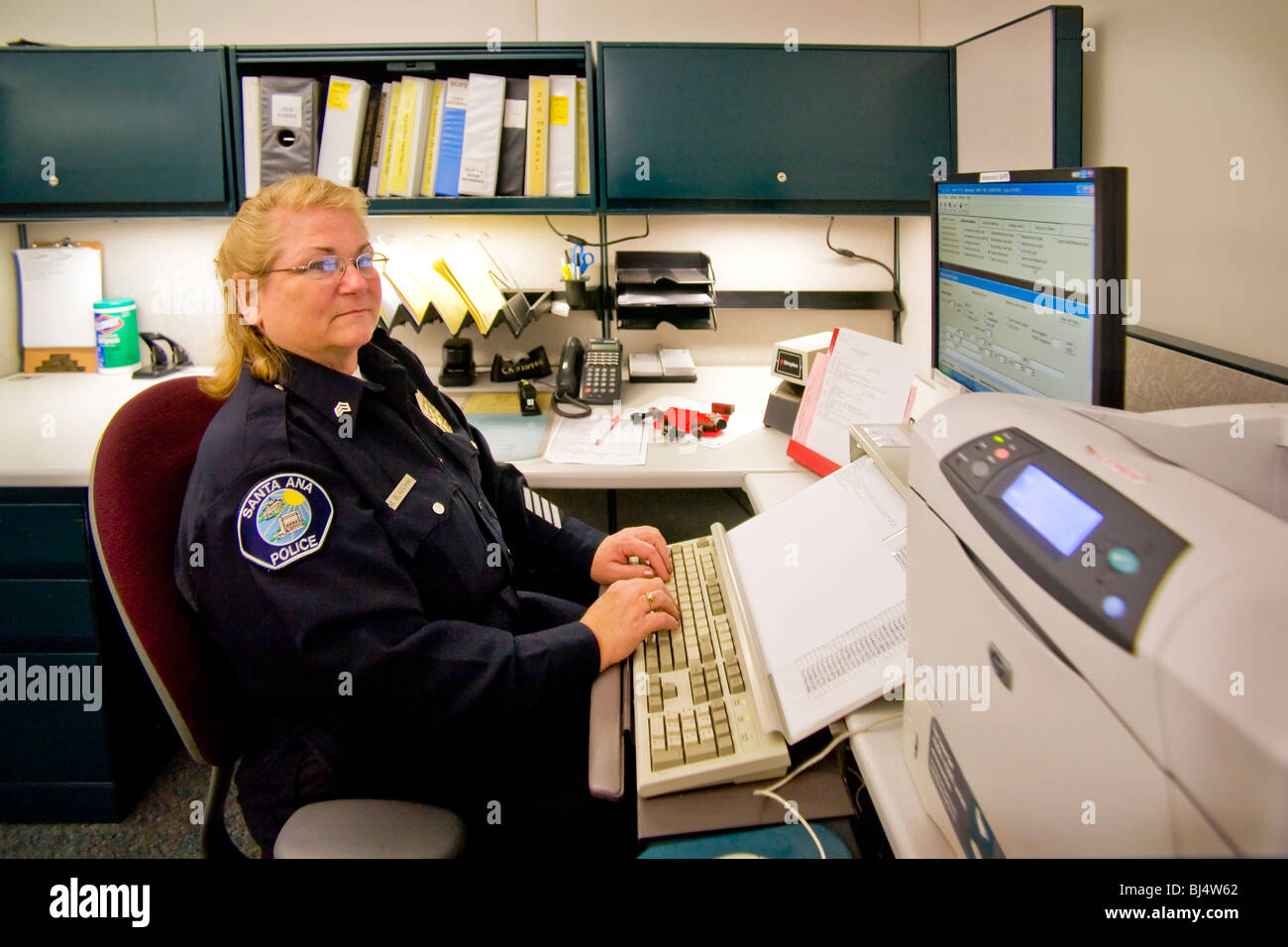Une femme sergent exploite l'appareil dans les registres de la division de Santa Ana, Californie, un service de police. Banque D'Images