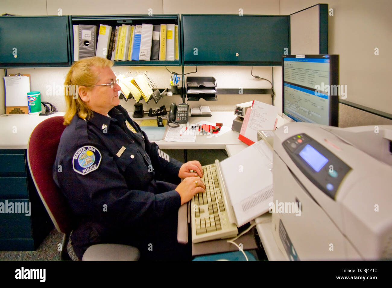 Une femme sergent exploite l'appareil dans les registres de la division de Santa Ana, Californie, un service de police. Banque D'Images