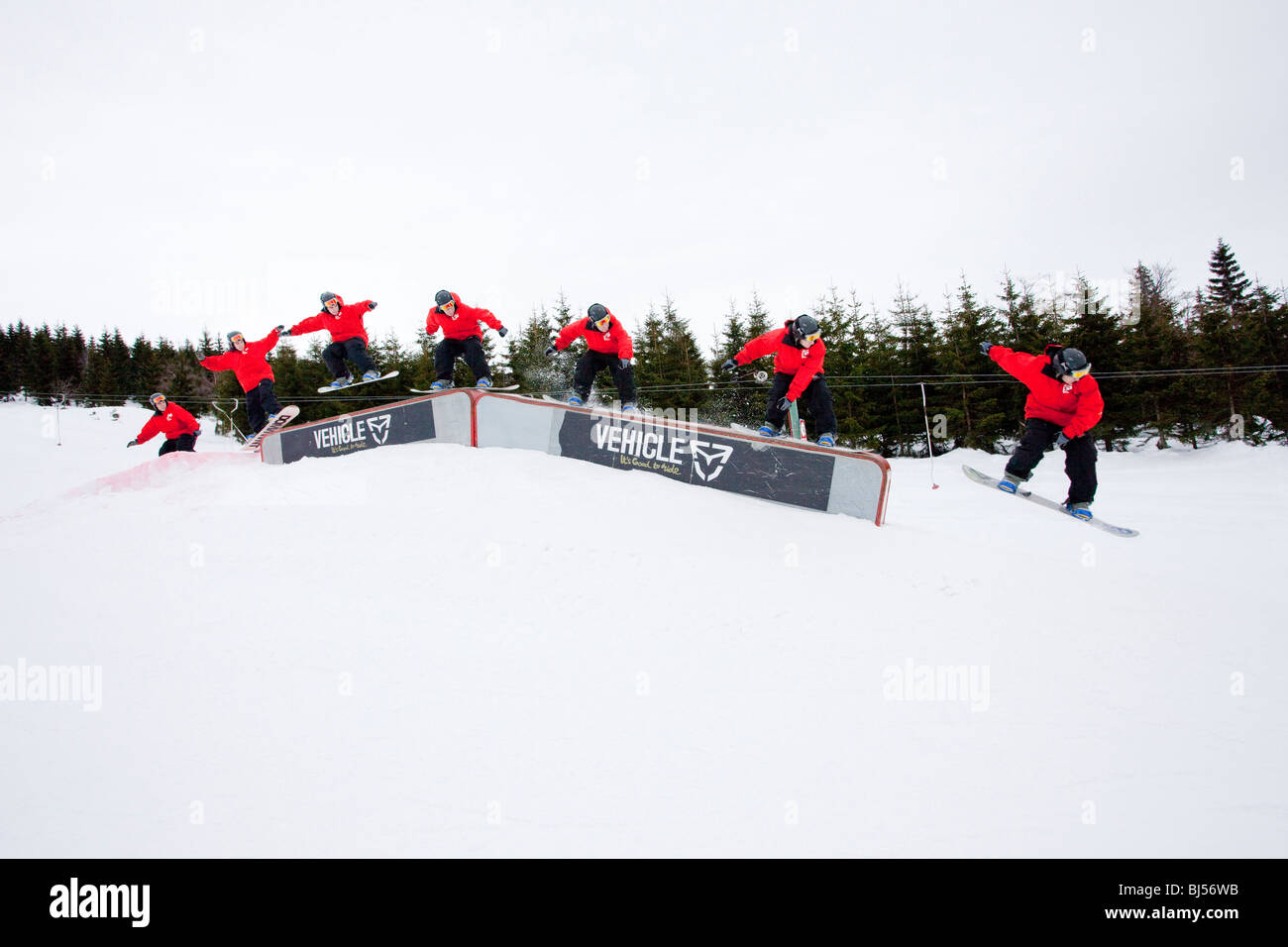 Homme snowboard, la séquence de plusieurs coups. Un homme portant une veste rouge fait du snowboard sur une rampe. Couvert. Banque D'Images