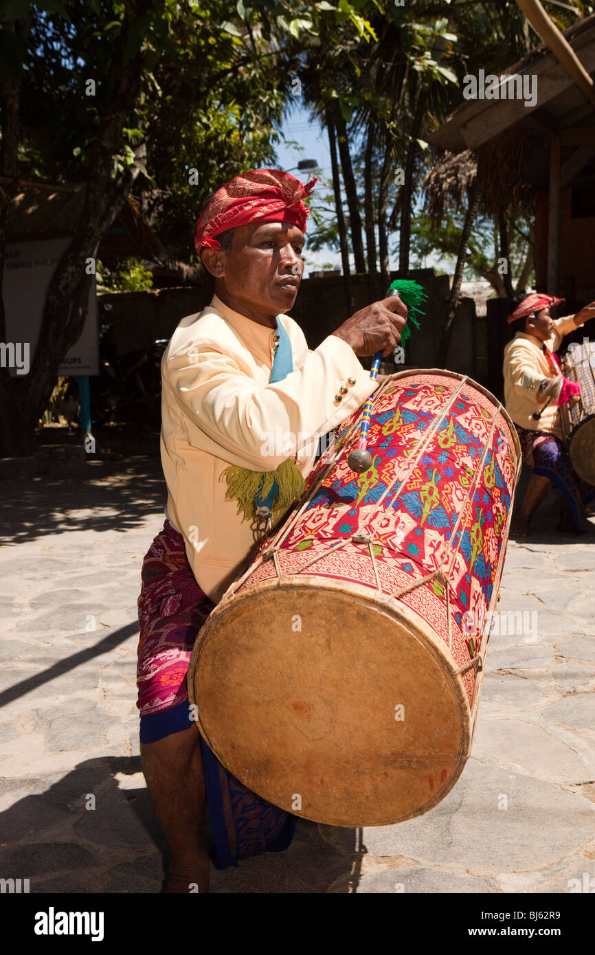 L'Indonésie, Lombok, Sade, village Sasak traditionnels, joueur de tambour pour groupe de touristes en visite bienvenue Banque D'Images