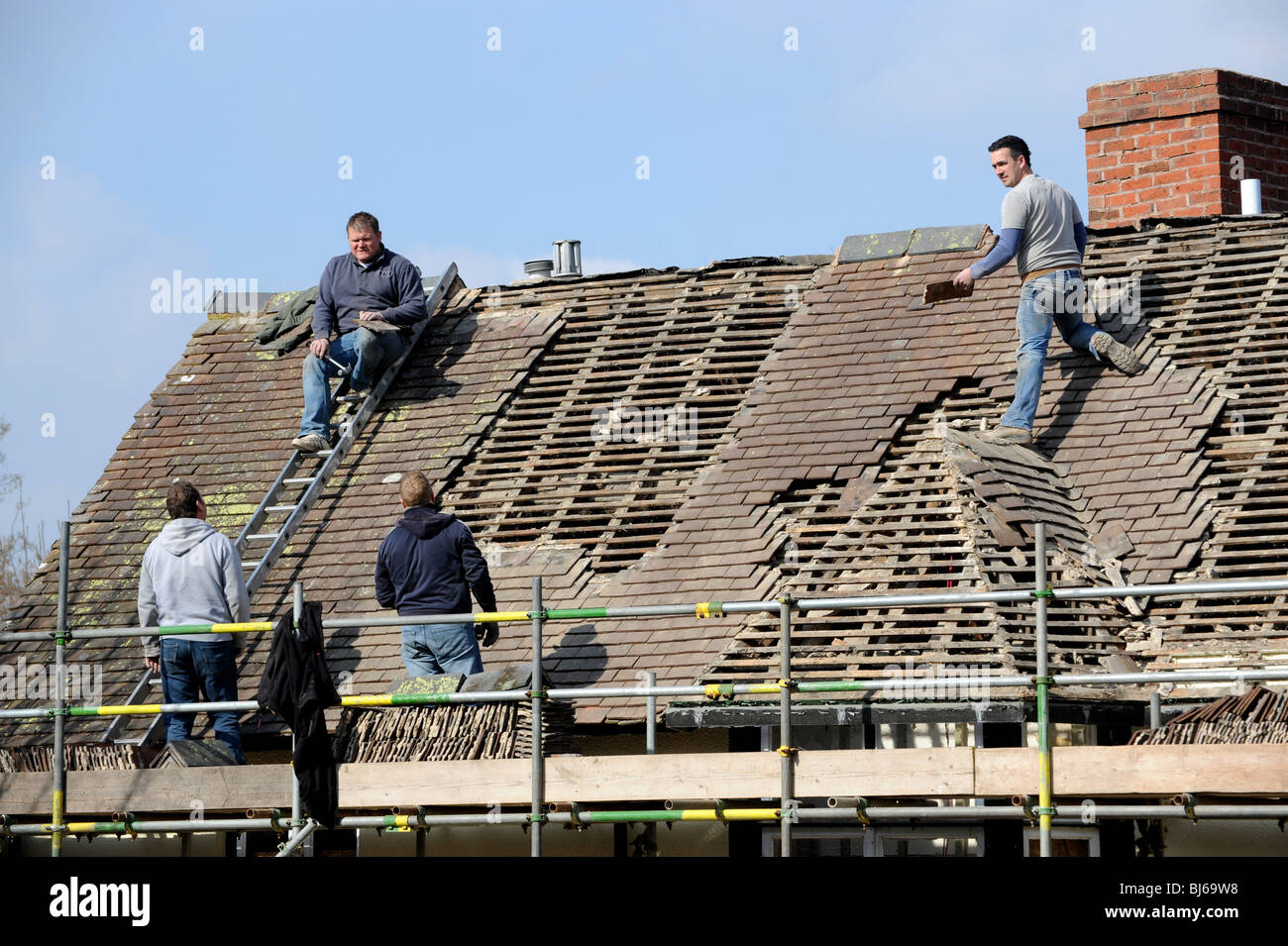 Carreleurs toit travaillant sur vieux bâtiment dans Leintwardine Herefordshire Angleterre Uk Banque D'Images