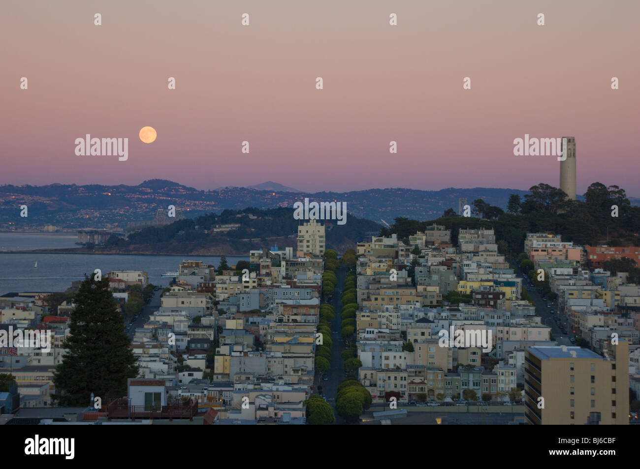 La Coit Tower et de Telegraph Hill, San Francisco, avec la pleine lune qui s'élève au-dessus de la baie de San Francisco Banque D'Images