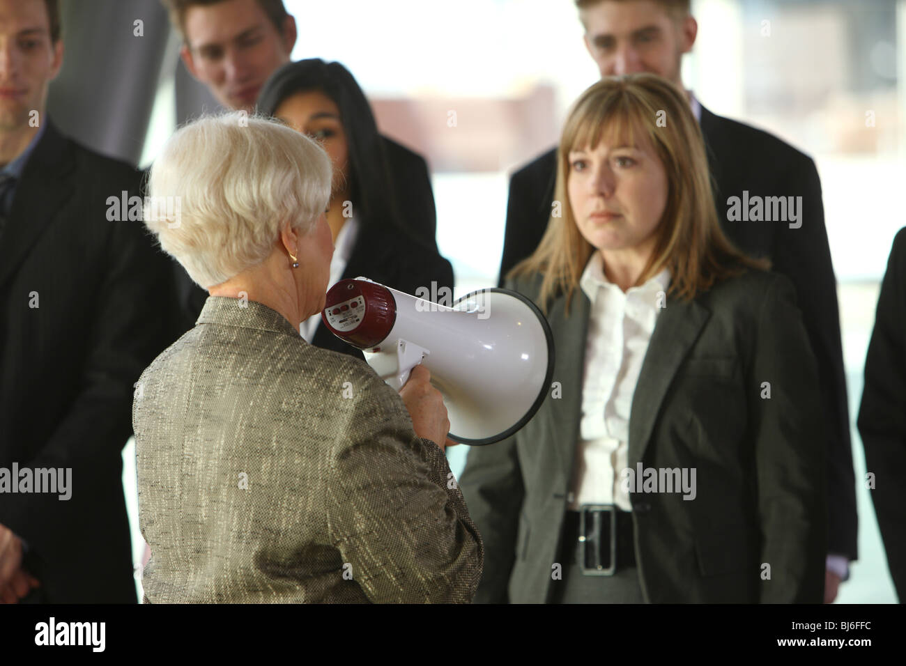 Boss yelling at employés with megaphone Banque D'Images