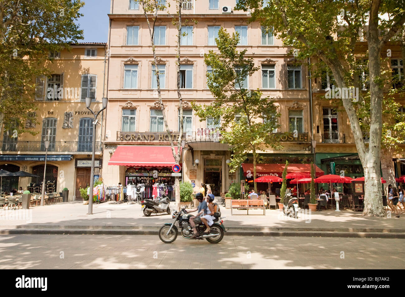 Une rue en Provence-Alpes-Côte d'Azur, Bouches-du-Rhône, Aix-en-Provence. Après-midi d'été avec circulation intense. De nombreux touristes et habitants sont vus. Banque D'Images