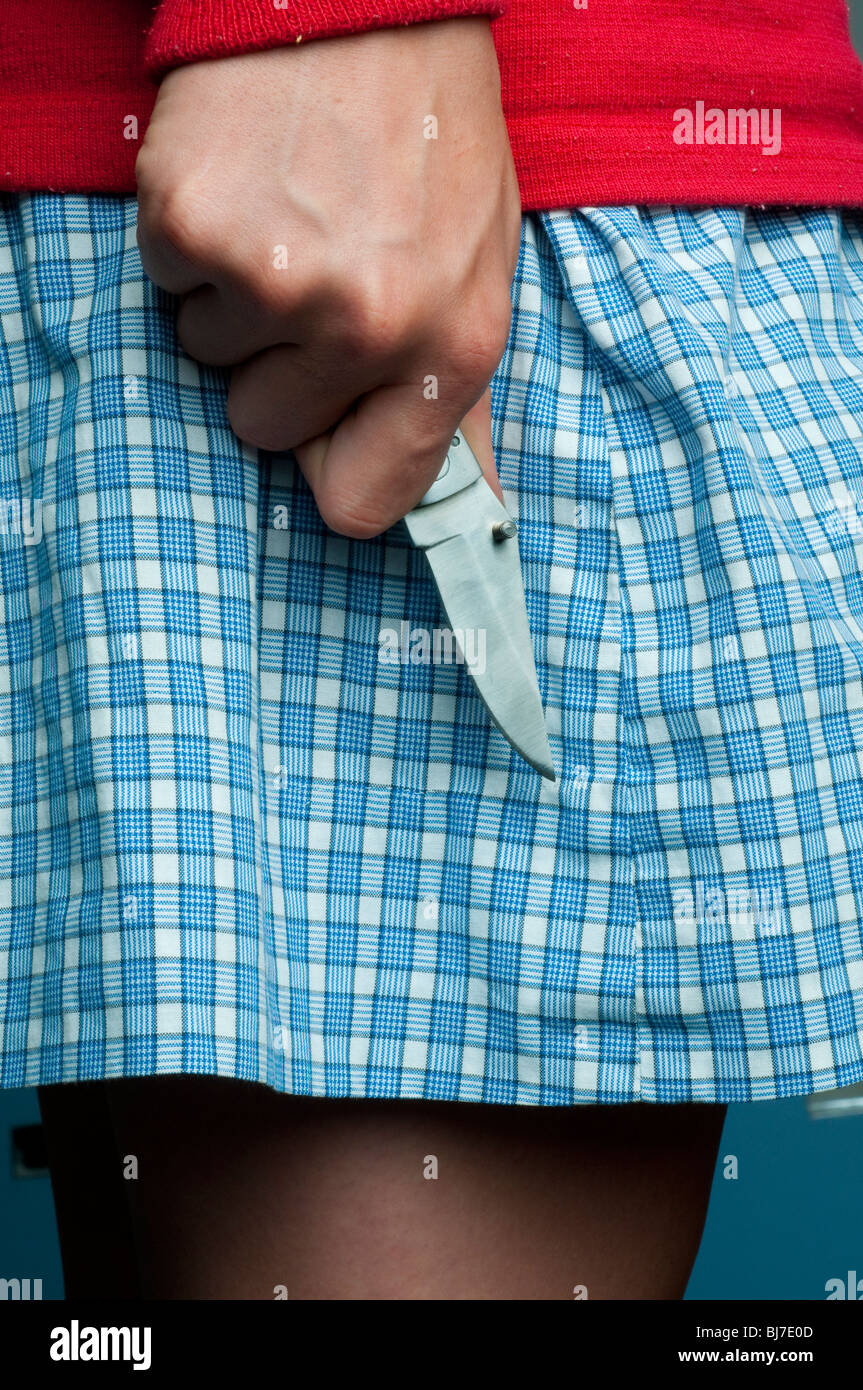 Le couteau dans la main d'une écolière Banque D'Images