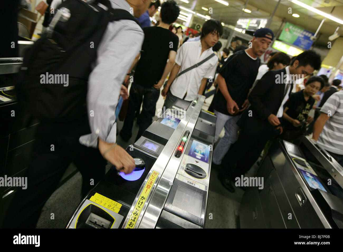 Les banlieusards d'utiliser leur téléphone mobile, activé avec le crédit financier, de passer par le ticket portes de la gare, le Japon. Banque D'Images