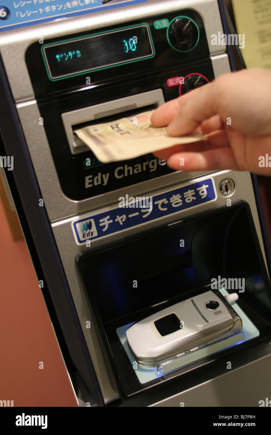 Une mère paie pour sa famille à l'aide de l'épicerie de l'Edy-card wallet fonction de son téléphone mobile, dans un supermarché au Japon. Banque D'Images