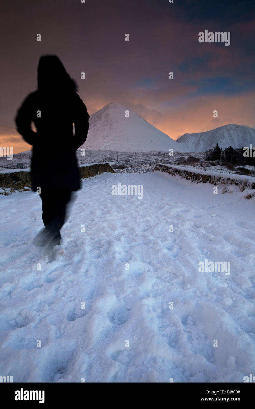 Une personne qui marche plus de Sligachan Bridge dans la neige, à l'île de Skye, en Ecosse Banque D'Images