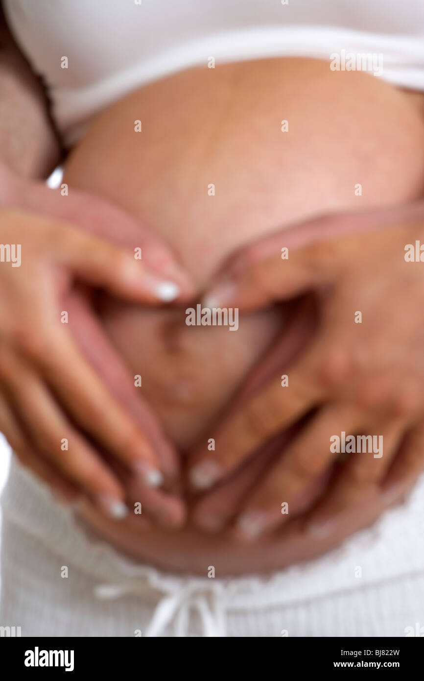 Floue flou artistique 8 mois 30 ans, femme enceinte avec 37 ans homme partner holding baby bump Banque D'Images