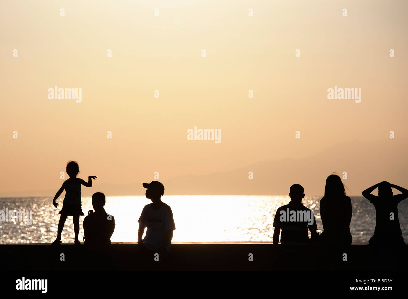Silhouette de personnes regardant le coucher du soleil sur la baie de Manille, de Manille, Philippines Banque D'Images