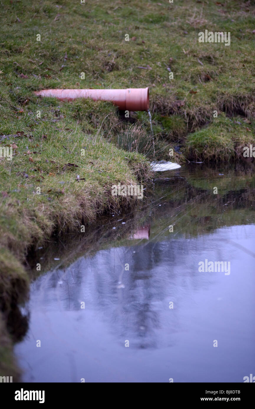 Se jetant dans l'eau du tuyau d'évacuation du marais de fossé Banque D'Images
