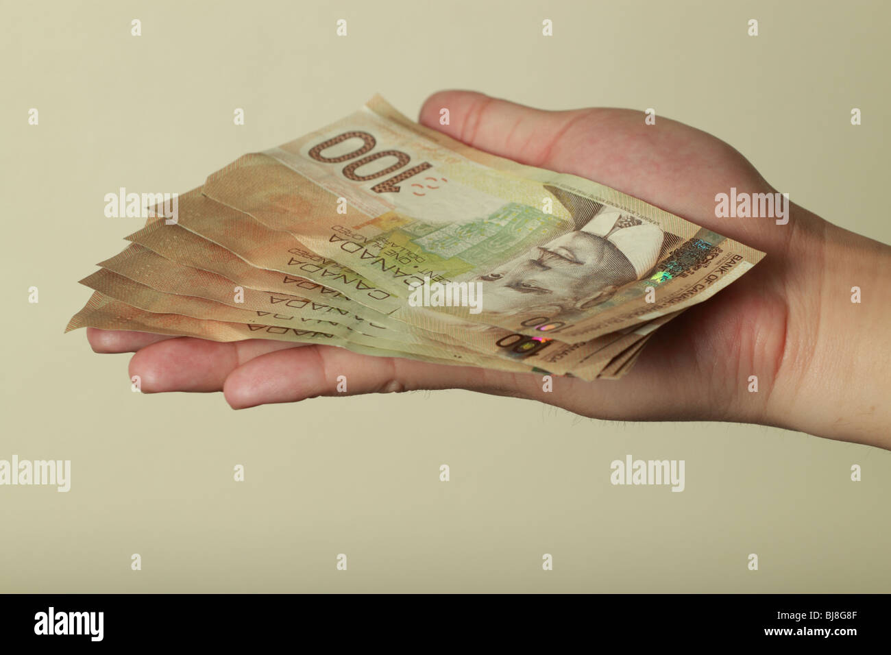 Une main tenant une pile d'une centaine de dollars. Banque D'Images