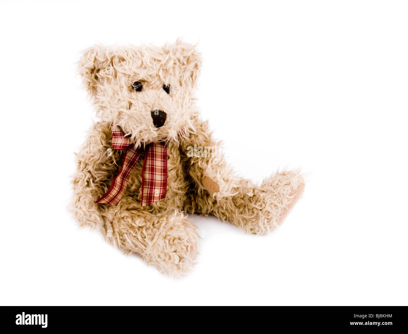 Teddy-bear brun avec arc rouge sur fond blanc. Banque D'Images