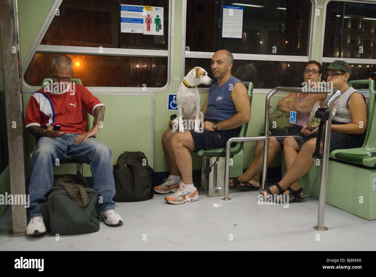 Vaporetto transport par eau, vie quotidienne vénitienne, homme avec chien de compagnie assis sur ses genoux, tard dans la soirée tout le monde rentre à la maison après une longue journée. Le chien regarde le garçon tirer un drôle de visage idiot. Venise Italie des années 2009 2000 HOMER SYKES Banque D'Images