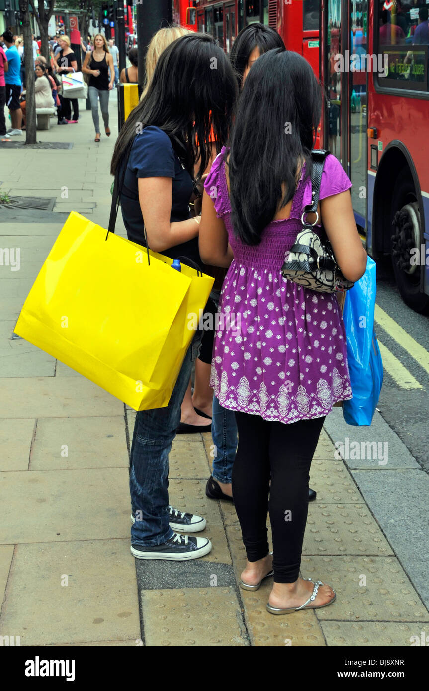 Femme transportant un sac jaune dans Selfridges Oxford Street supprimé de façon numérique sac jaune voir également Alamy BJ8XNR Banque D'Images