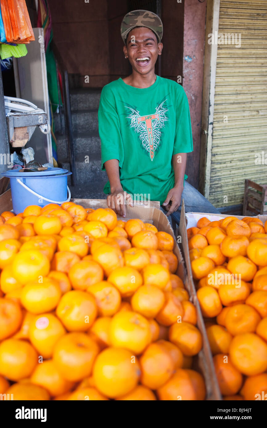 Vente garçon oranges ; marché de Parañaque Paranaque, de Manille, Philippines Banque D'Images