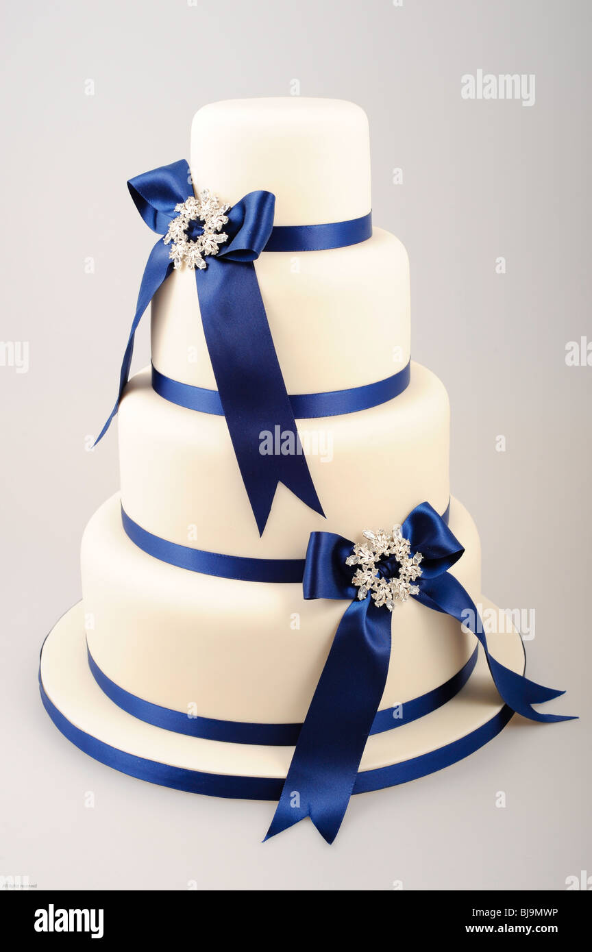 Gâteau à quatre niveaux avec des rubans bleu royal en arcs avec diamond centre Banque D'Images