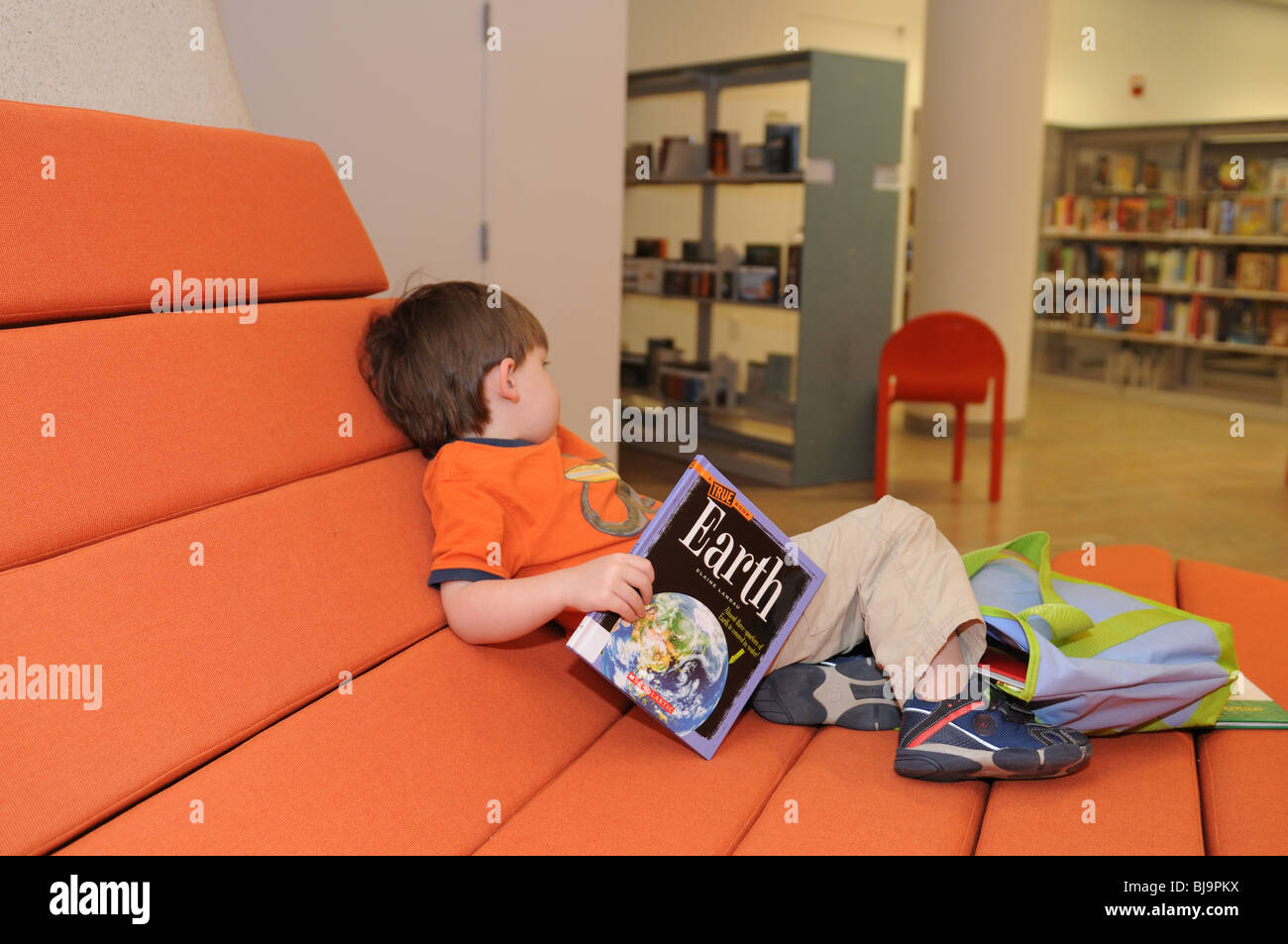 Le jour de l'ouverture de la bibliothèque de Battery Park City, un garçon de trois ans qui a trouvé un livre sur terre à lire. Banque D'Images