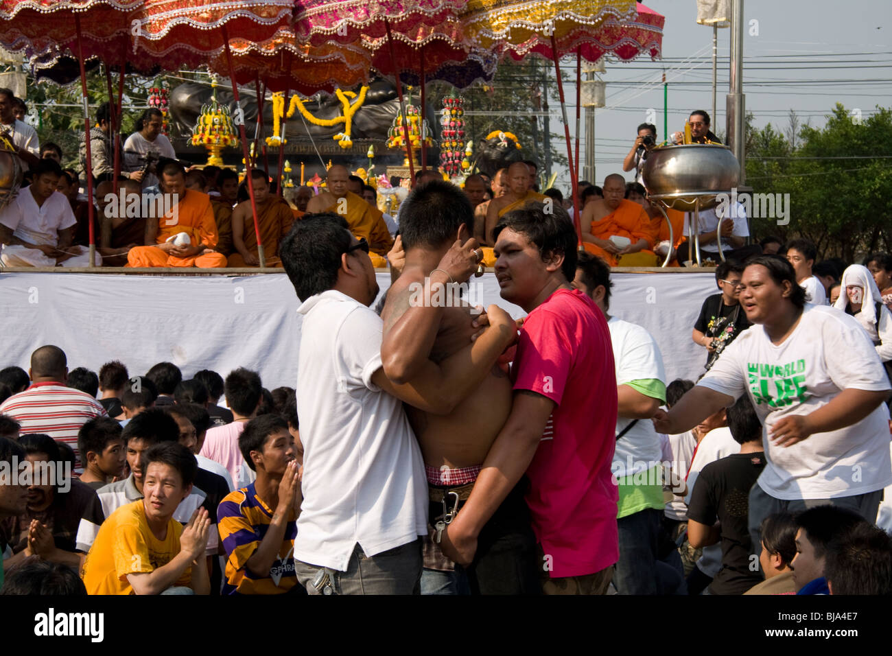 Un homme en transe est calmée au cours de Wai Kru Journée à Wat Phra Bang, un temple bouddhiste en Thaïlande où les moines dévots de tatouage. Banque D'Images