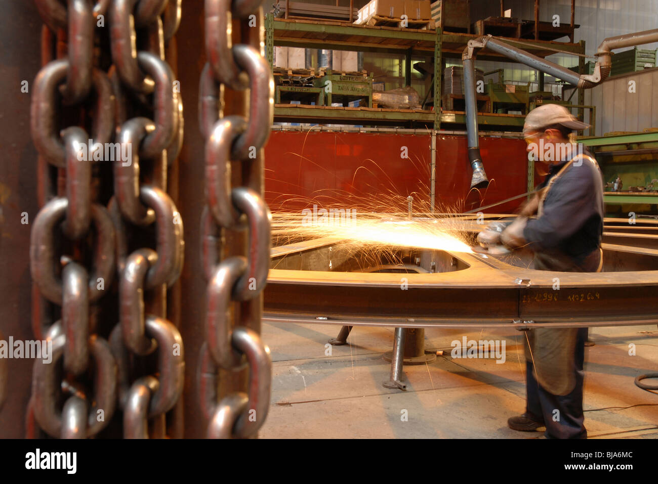 L'homme du meulage d'une roue de téléphériques dans une usine du groupe Leitner, Italie Banque D'Images