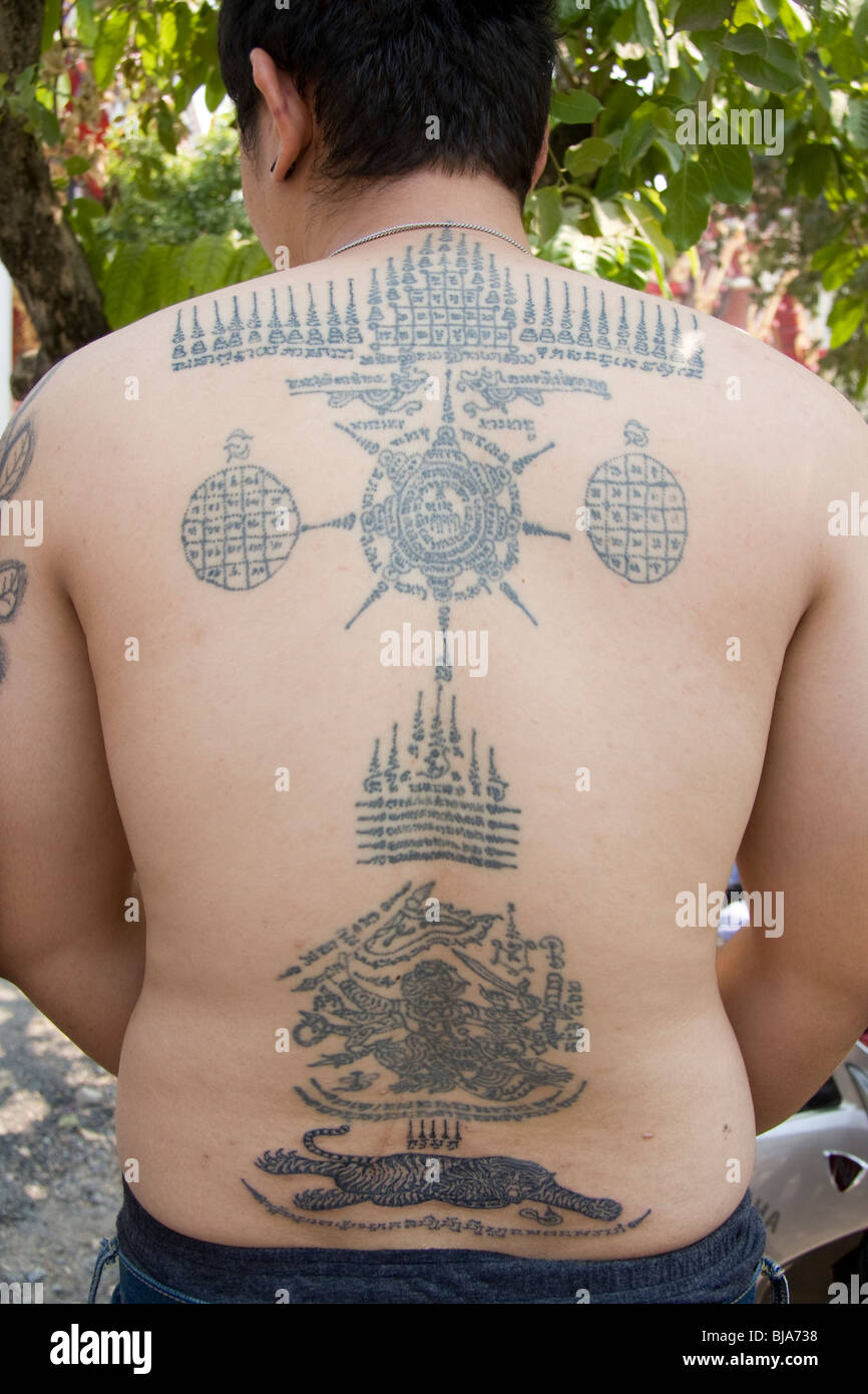 Un jeune homme est de retour au Wat Bang Phra tatouages temple en Thaïlande, où les moines dévots leur tatouage avec des prières. Banque D'Images
