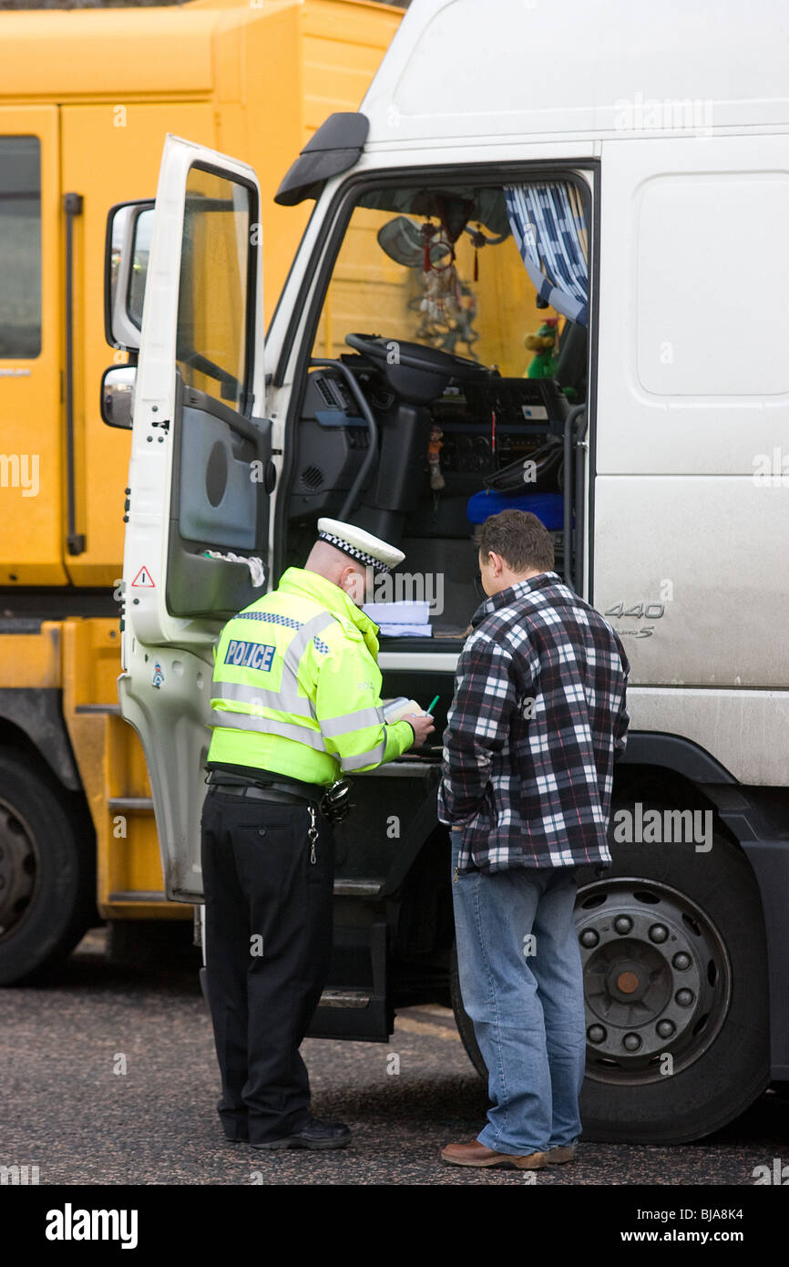 Les agents de police étrangers parler à un conducteur de camion à un poste de contrôle VOSA Banque D'Images