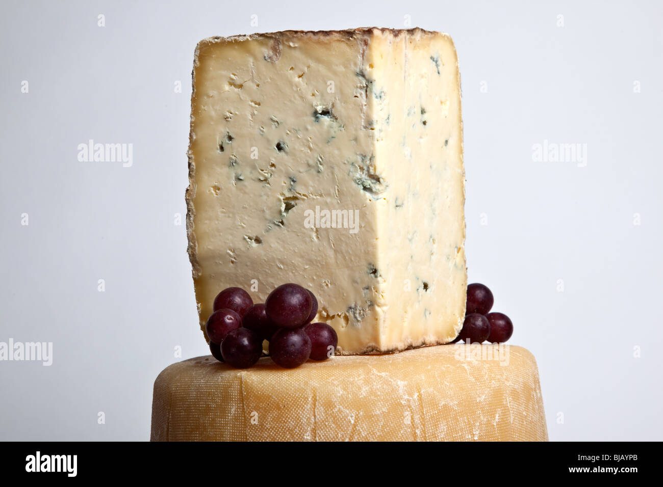 Tout un fromage rond avec un grand support de fromage bleu dans une tour avec des raisins Banque D'Images