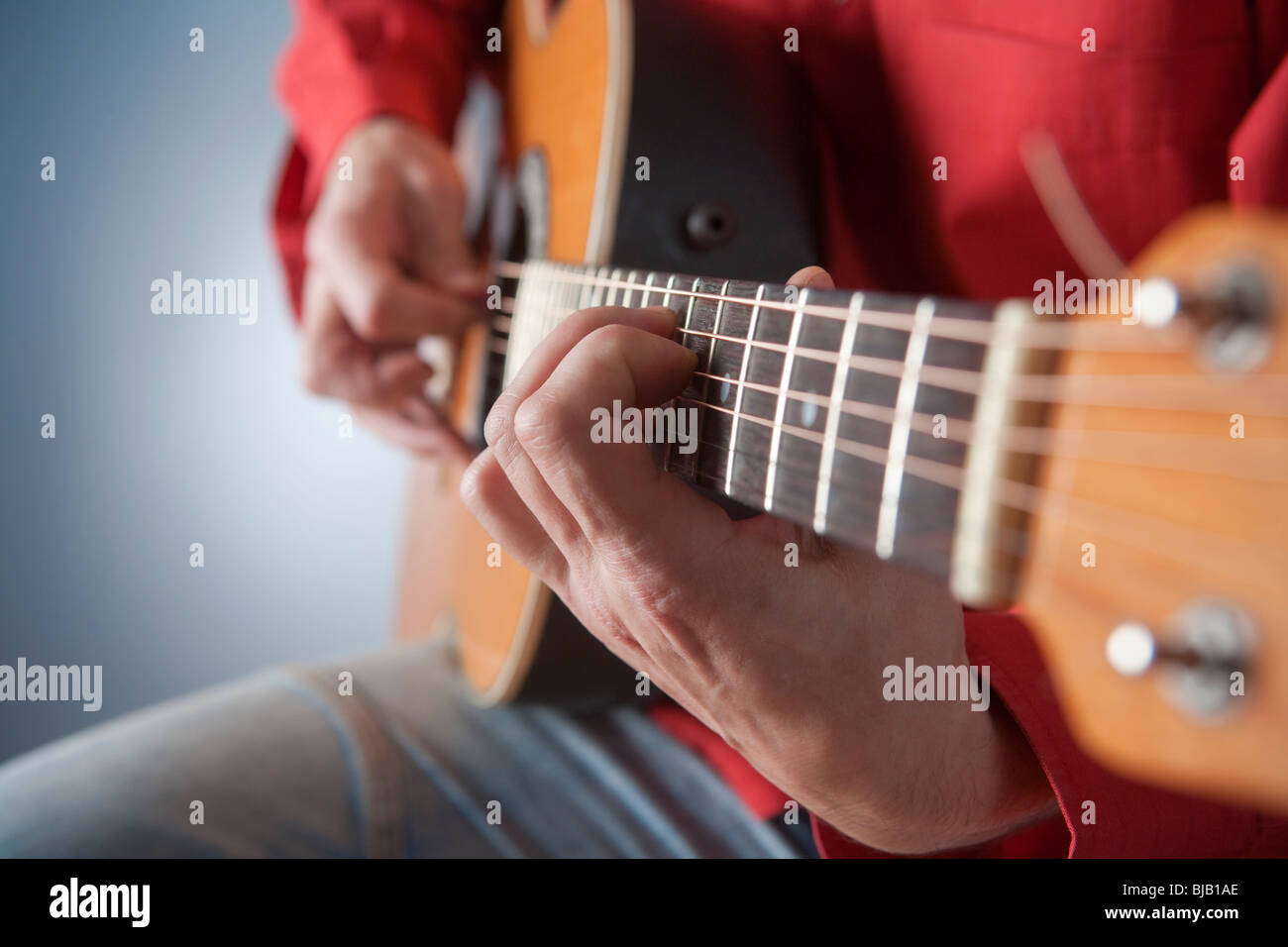 Libre de mains d'un musicien jouant de la guitare acoustique Banque D'Images