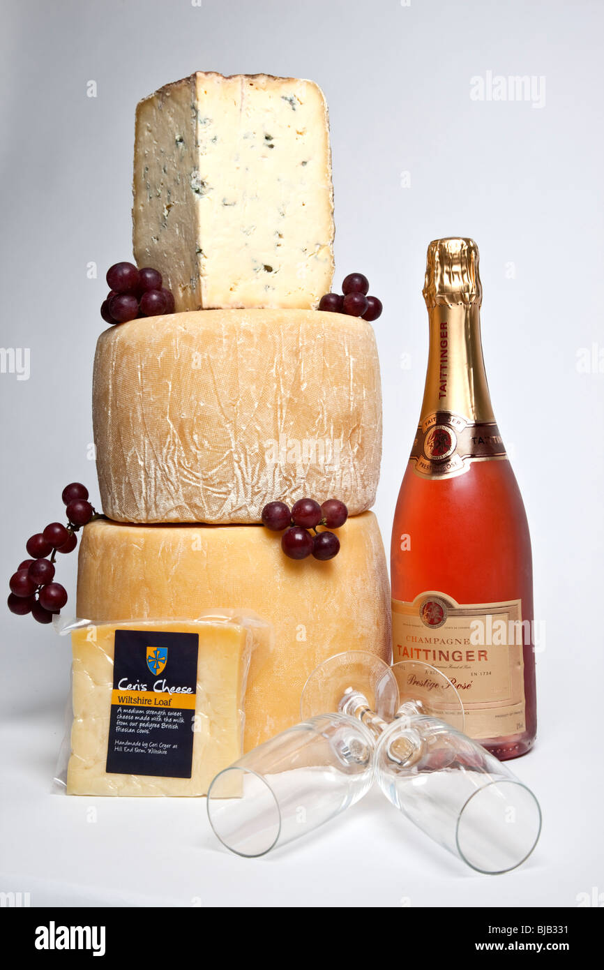 Une célébration de la tour ronde de fromages entiers avec un grand support de fromage bleu avec une bouteille de champagne et deux verres rose Banque D'Images
