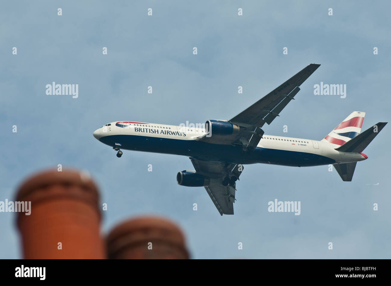 British Airways avion volant à basse altitude au-dessus des maisons à proximité de l'aéroport de Heathrow. Banque D'Images