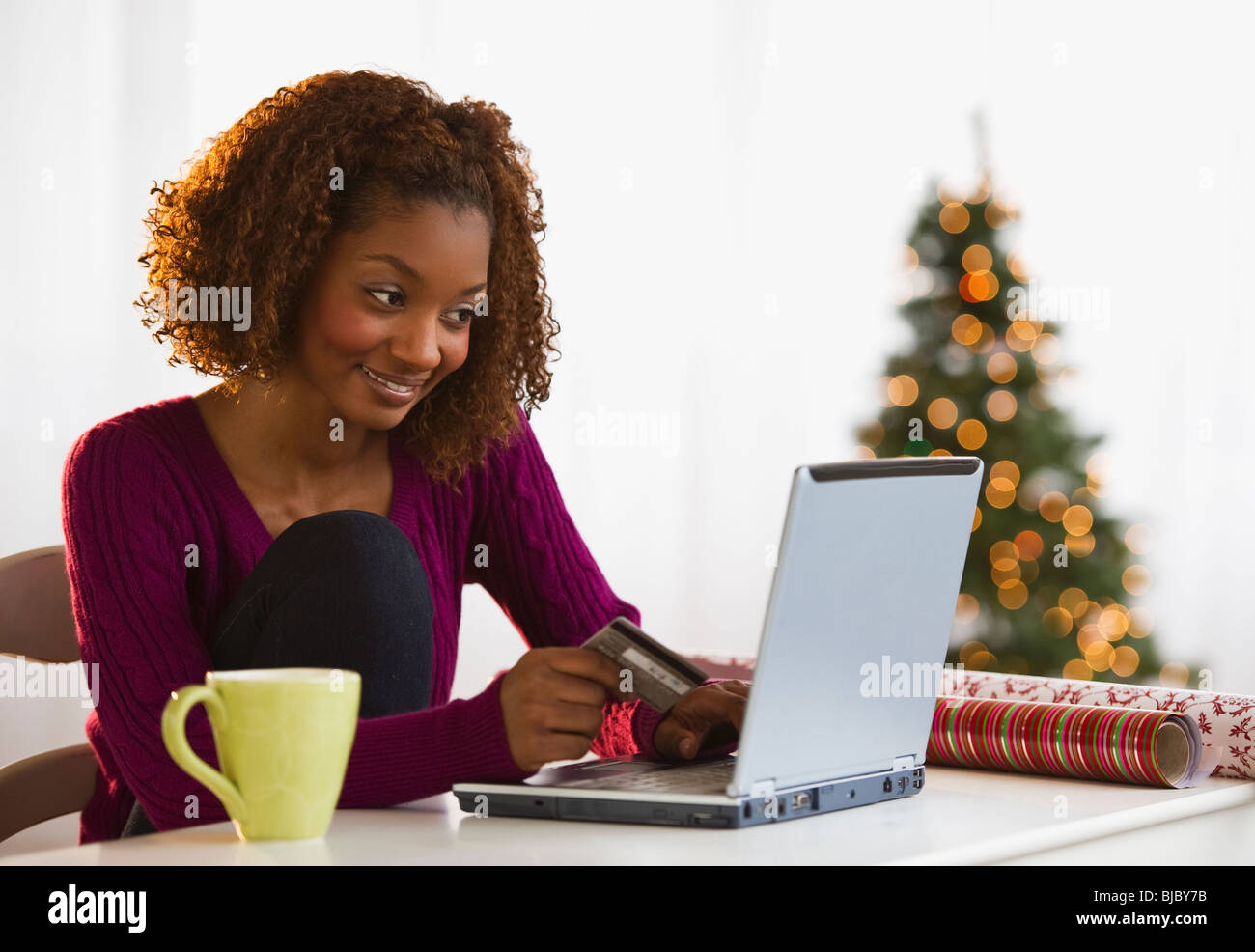 Mixed Race woman shopping de Noël sur internet avec carte de crédit Banque D'Images