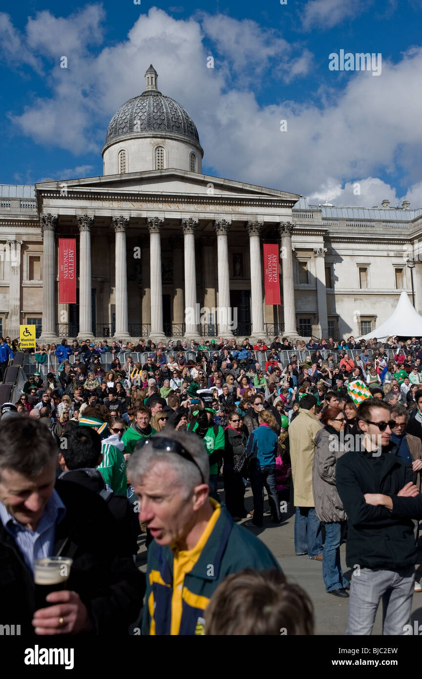 Une grande foule assise sur les marches à l'extérieur de la Galerie nationale au cours de la fête St Patricks Day à Londres Banque D'Images