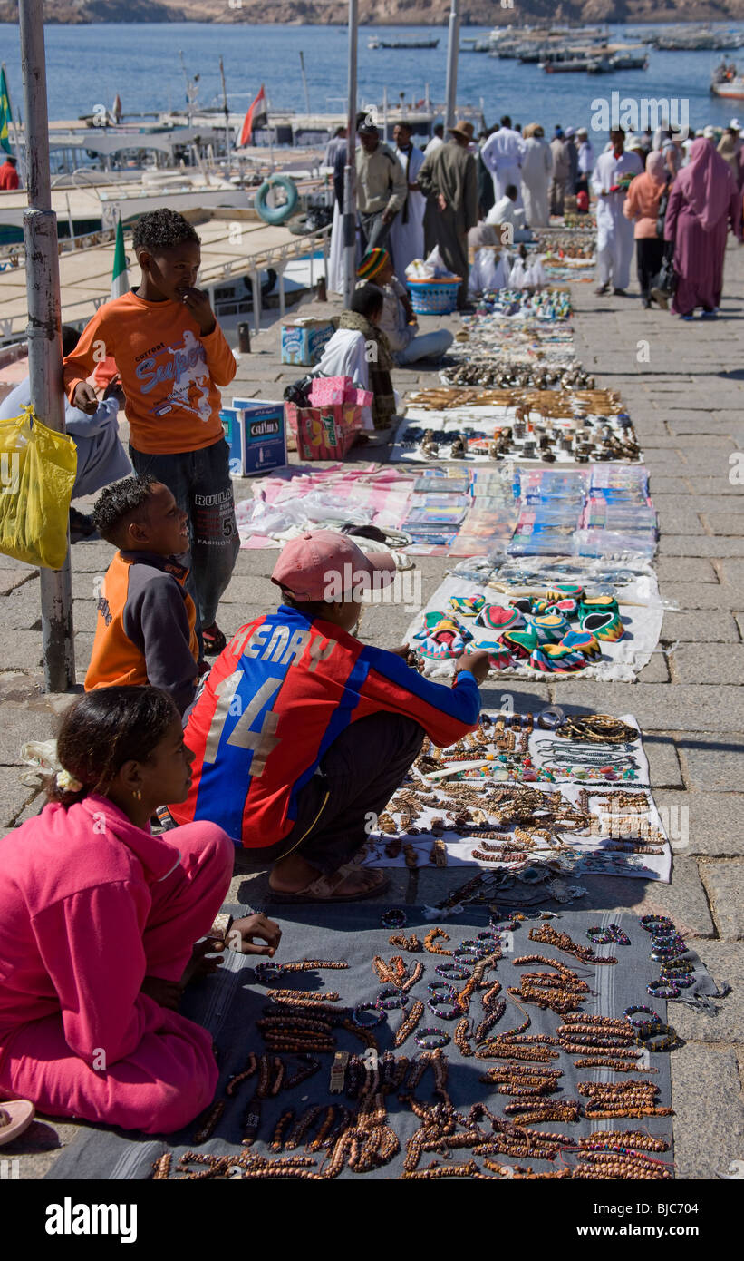 Les jeunes égyptiens avec leurs marchandises exposées le long de la promenade au quai à Assouan, prêt à vendre des babioles aux touristes. Banque D'Images